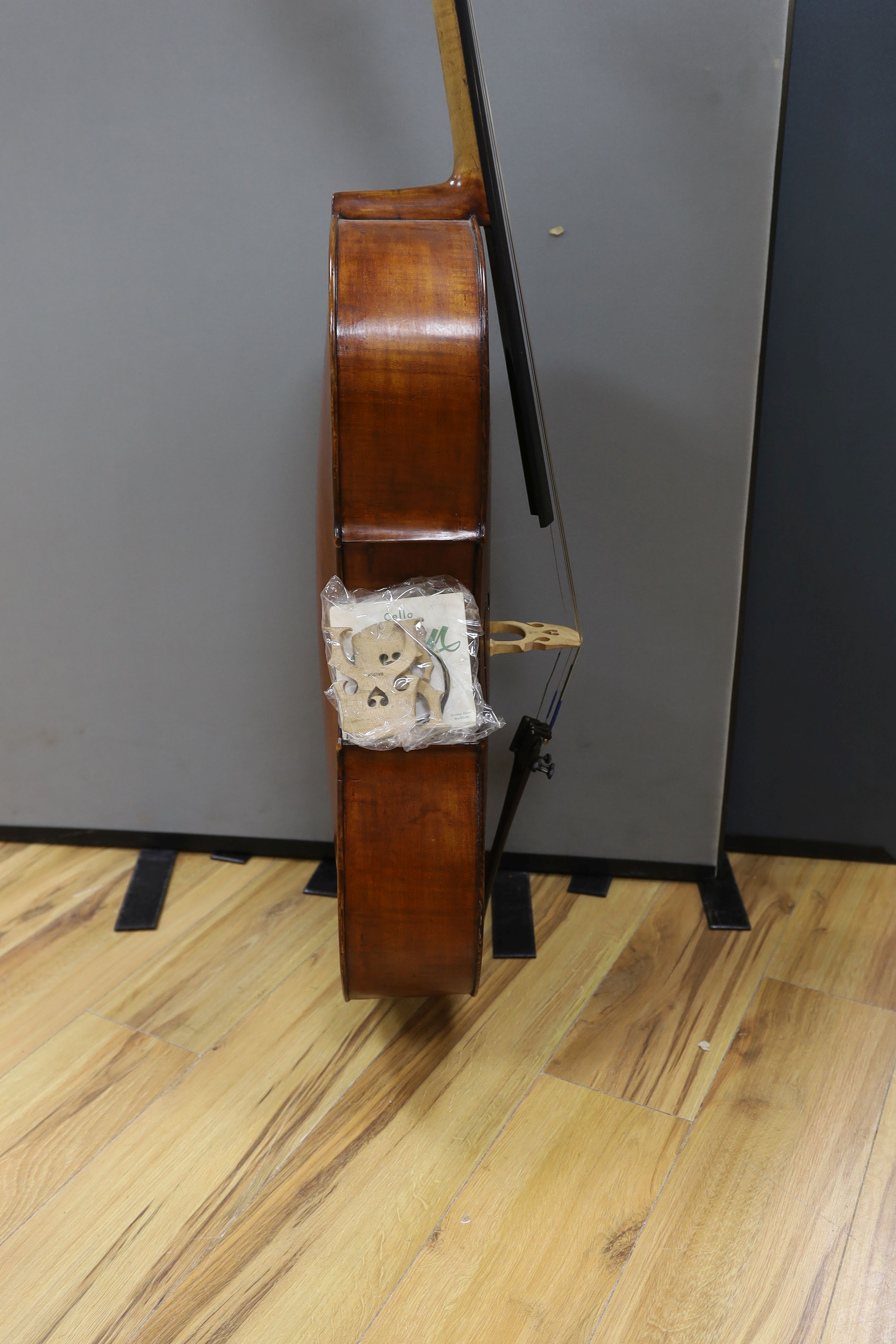 A cased early 20th century ‘cello, length of body 75.5cm, with two spare bridges, and spare strings